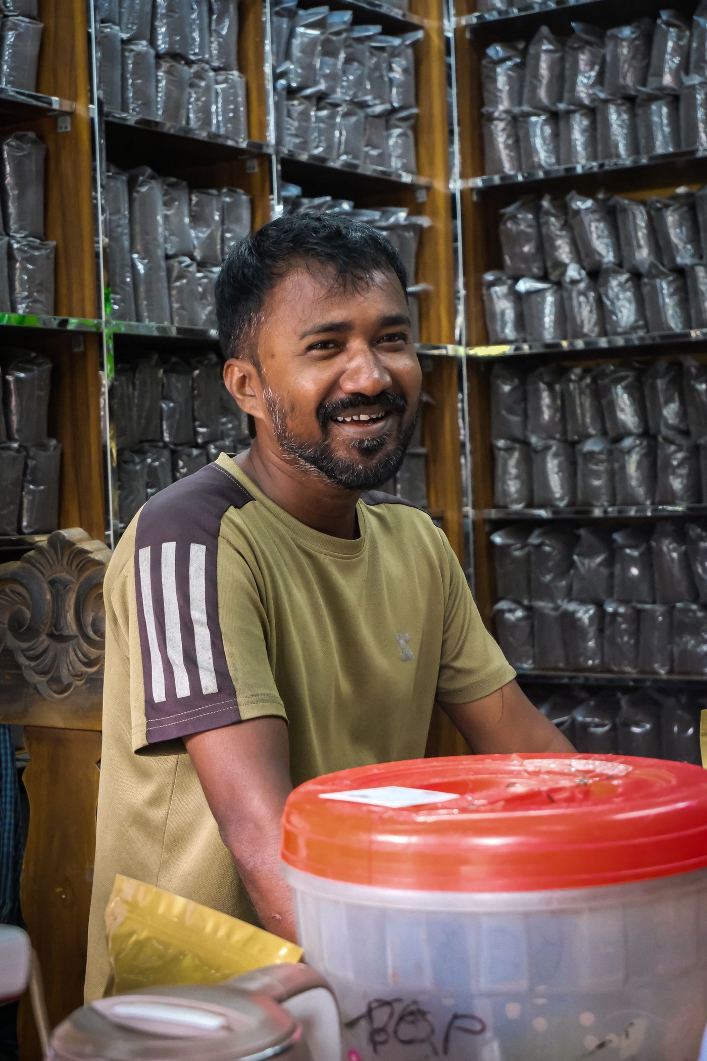 A tea and spice seller weighing loose leaf behind a counter